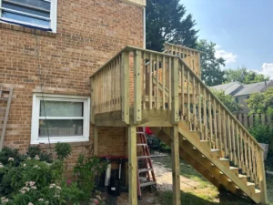 Custom wood deck construction with stairs at a brick home in Maryland