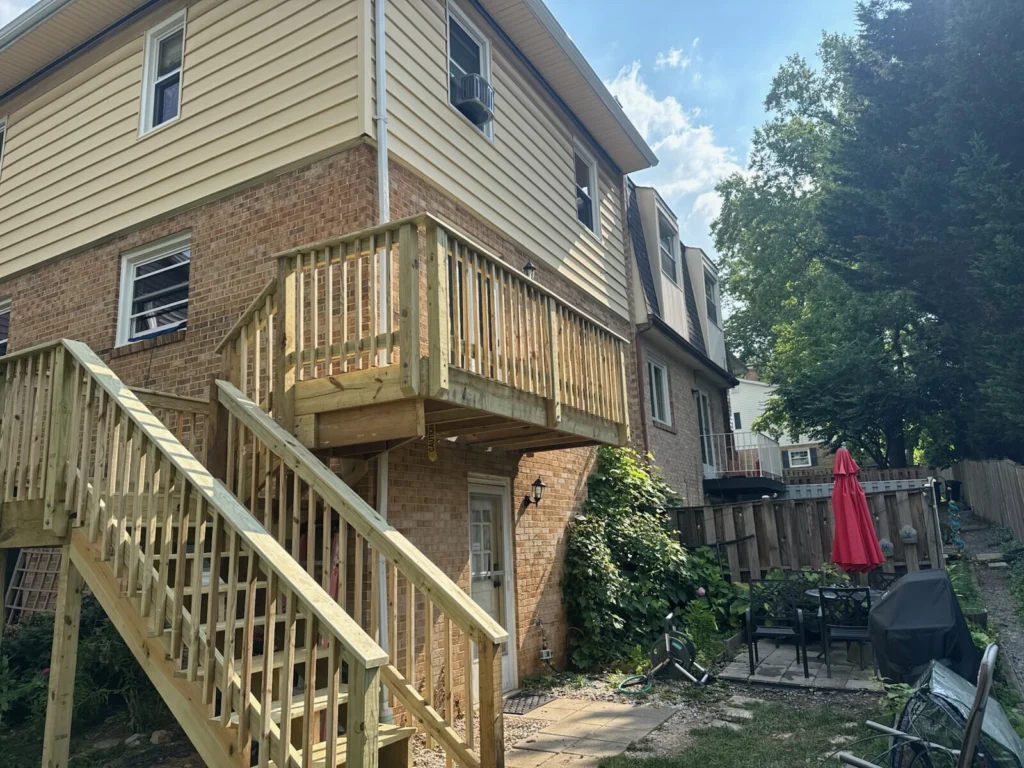 New pressure-treated wood deck with stairs built on brick townhouse backyard in Maryland