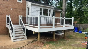 Custom composite deck with white railings and black balusters on backyard home in Maryland