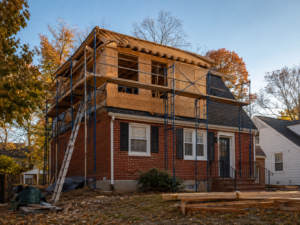 Two-story home addition under construction on a brick Cape Cod in Arlington, Virginia